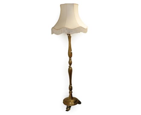 A Brass Standard Lamp and Shade, circa 1900, the acanthus scrolled fitment on a baluster turned support with moulded base and
