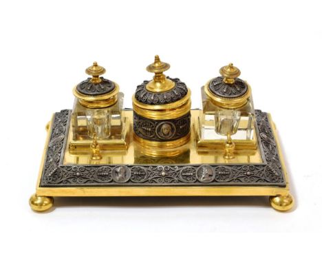 A Brass Inkstand, early 19th century, with central circular pot and cover flanked by two glass inkwells and covers, on a rect