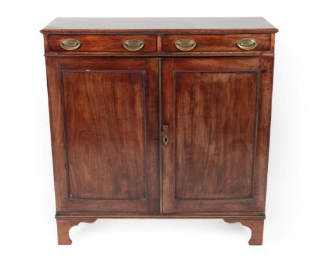 ^ A George III Mahogany Cabinet, early 19th century, the moulded top above two frieze drawers and two moulded cupboard doors 