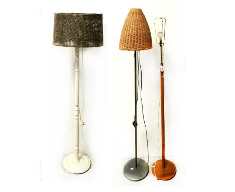 Three various standard lamps to include a mid-20th century turned wooden example, a modern metal and wicker lamp shade and a 