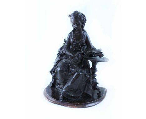 A bronze figure of a seated young woman reading a book of music, height 36cm.