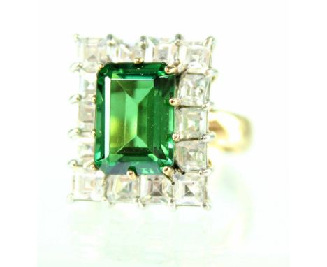 A 9ct yellow gold ladies' dress ring set with large central emerald with fourteen white stone surround, size Y.