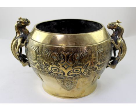 A Chinese brass or polished bronze planter with twin Chilong handles and Taotie masks to either side against Greek Key band w