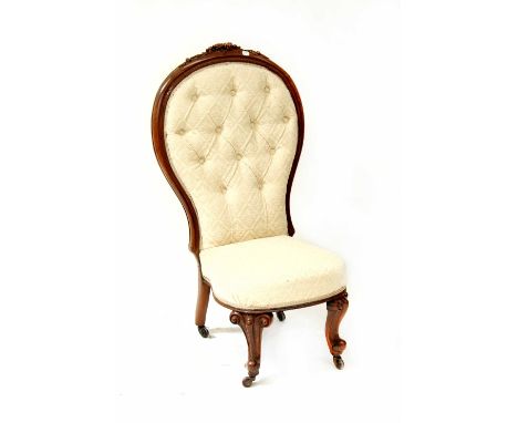 A Victorian walnut spoon back bedroom chair with carved decoration, on squat cabriole legs, upholstered in a button-back crea