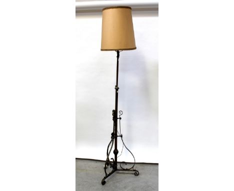 A brass standard lamp converted to electricity with three outswept scrolling supports, height including shade 194cm. CONDITIO