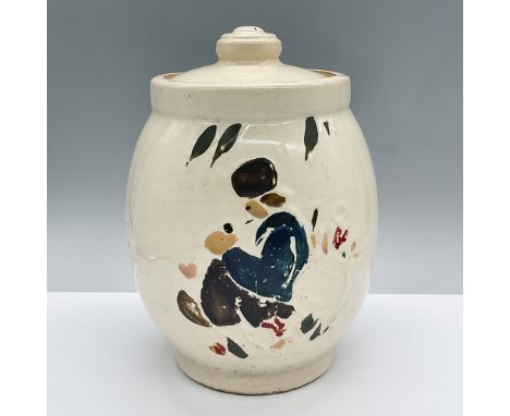 This ceramic cookie jar features a painting of a seated figure with a hat.Issued: 20th centuryDimensions: 6.75"L x 6.75"W x 9