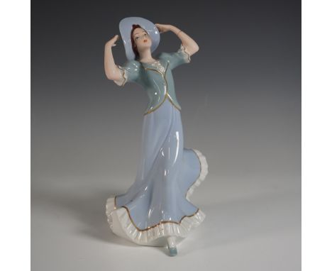A stunning Royal Dux Bohemia porcelain figurine featuring a gracefully posed woman in a flowing pastel blue gown with gold tr
