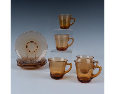Beautifully decorated with a raised lace border over amber-colored glass, this set includes five matching cups and saucers. C