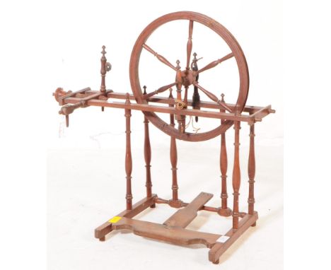 A Victorian 19th century wooden spinning wheel. The wheel raised on turned bobbin supports, with a central six spoke spinning