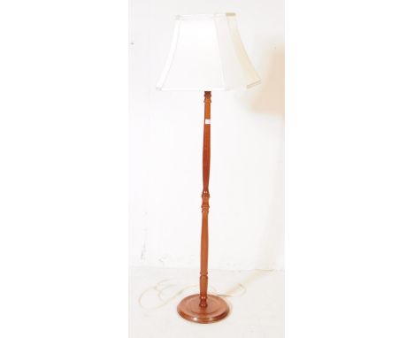 A 20th century turned mahogany floor standing standard lamp. The lamp raised on a rounded base, with a turned central column.