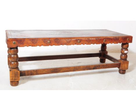 An early 20th Century leather topped oak construction coffee table with turned bobbin legs with stretcher supports. Leather t