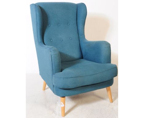British Modern Design - A contemporary wingback armchair. In a teal colourway with button back design all supported on turned