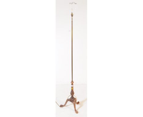 An early 20th century brass and wood floor standing standard lamp. Having reeded central column into a carved foliate wooden 