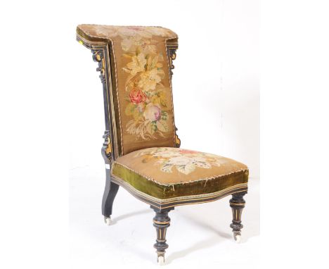 A Victorian late 19th century ebonised wood prie-dieu nursing chair. With a rectangular T back rest with needlepoint upholste