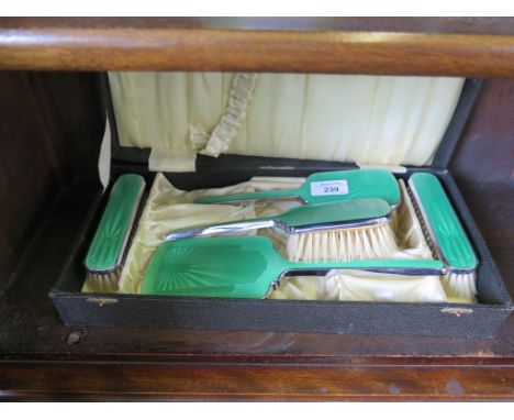 A cased five piece mirror and brush set with green enamel and chrome