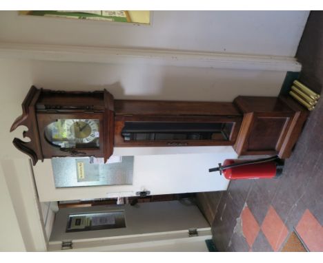 A mahogany longcase clock by Emperor, the broken arch over a brass dial and glazed trunk door, the three train movement strik