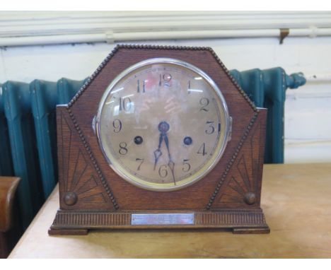 A 1930s oak mantel clock, of angular form with sunbursts and silvered dial, the twin train movement striking on a gong, 22.5c
