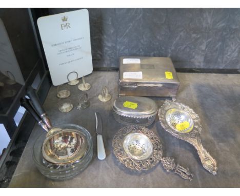 A collection of silver and silver plated items to include six plated menu holders, two tea strainers, a cigarette box, a chil