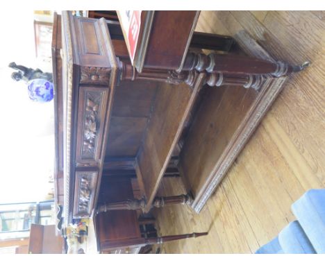 A late Victorian carved oak buffet, with two carved frieze drawers and fluted turned supports, 115cm wide, 45cm deep, 97cm hi