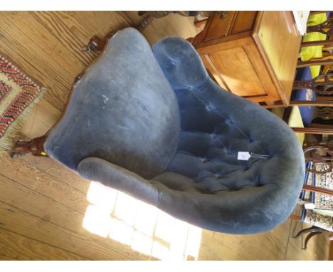 A Victorian button back armchair, in blue upholstery on moulded cabriole legs with pot castors