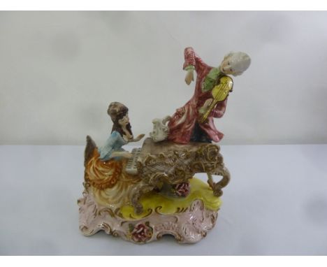 A Capo di Monte figural group of a lady playing a piano accompanied by a man playing a violin, 50cm (h)