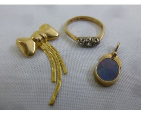 A quantity of 9ct gold jewellery to include a three stone diamond ring, a brooch in the form of a bow and a pendant set with 