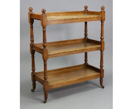 A Victorian oak rectangular three-tier dinner wagon on turned supports &amp; turned feet with ceramic castors, 35” wide x 43”