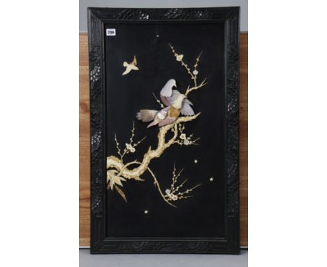 A Japanese black lacquered panel with mother-of-pearl inlaid decoration of birds amongst foliage, in carved ebonised wooden f