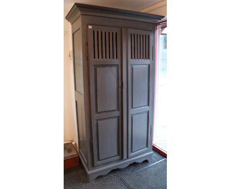 A continental-style blue/grey painted wooden two-door wardrobe with a moulded cornice, enclosed by a pair of fielded &amp; pi