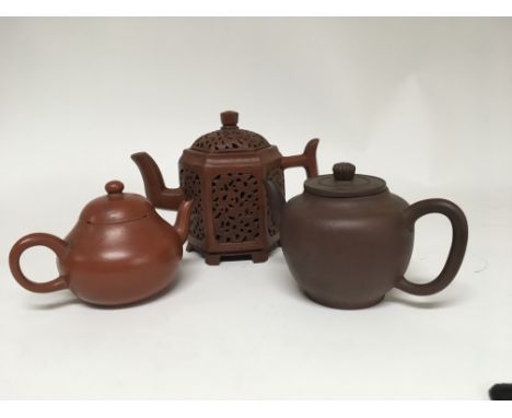 A Chinese terracotta hexagonal teapot with pierced sides with conforming lid seal mark to the base and two other unmarked ter