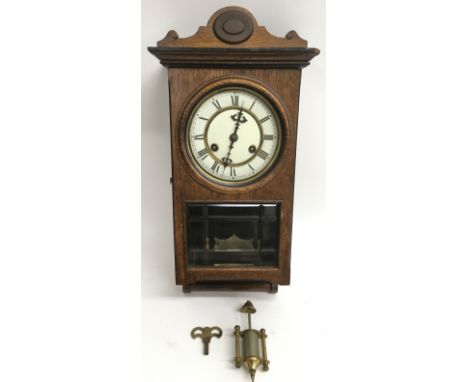 An oak and three glass panel wall clock with Roman numeral metal enamel dial.Aporox 18x41cm