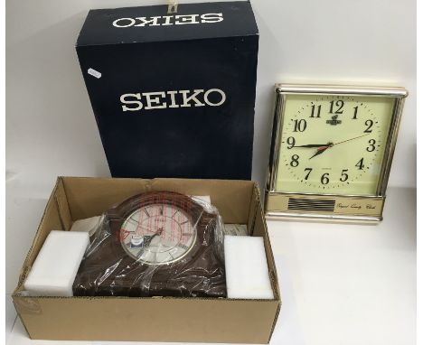 A boxed unused Seiko mantle clock and a Bell's whisky adverting wall clock