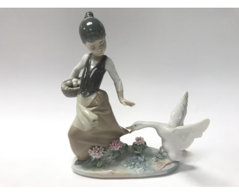 A Lladro figure of a girl and a goose. Some damage to flowers and wing of goose.
