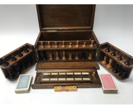 A cased games set including chess pieces, playing cards and cribbage.