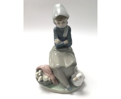 A Lladro figure of a girl with a goose.