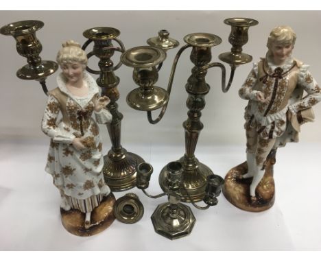 Silver plated candelabra and a pair of ceramic figures.