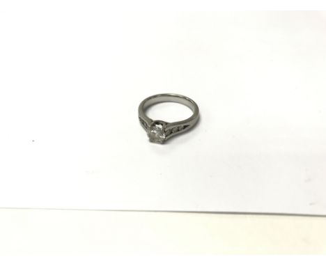 A platinum ring with 0.75 carat diamond flanked by 6 smaller diamonds. Weight approx 5.55g, size approx L