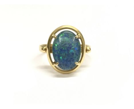 An 18ct gold doublet ring set with a large central black opal. Ring size Q/P, total weight approximately 4.6 grams.