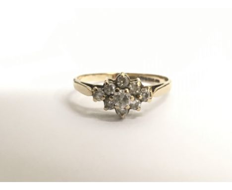 A ladies 9ct yellow gold ring set with nine white stones in diamond formation, ring size K/L. Total weight approx 2 grams.