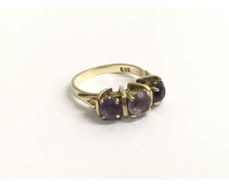 A ladies 14ct yellow gold ring marked 585, claw set with three amethyst stones. Ring size approximately L/M, total weight app