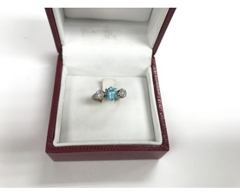 An 18ct gold ring set with diamond and possibly blue topaz central stone. Size approx J, weight approx 3g