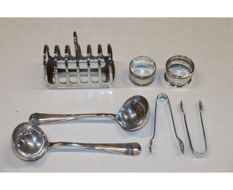 A silver plated six division toast rack; two pairs of silver plated sugar tongs; a silver napkin ring, a white metal napkin r