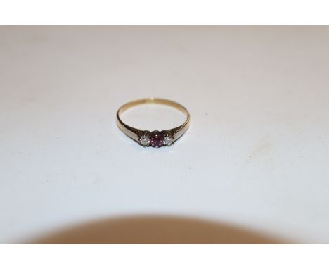 A yellow and white metal ring (mark rubbed) set with ruby flanked by diamonds, ring size S. Approx. 1.5g
