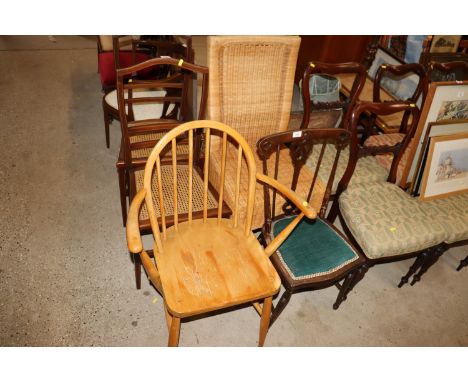 An Ercol stick back elbow chair together with a wicker dining chair and a bedroom chair