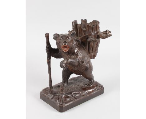 A GOOD 19TH CENTURY BLACK FOREST STANDING BEAR GLASS HOLDER, formed as a bear with stick, carrying a basket on his back. 11in