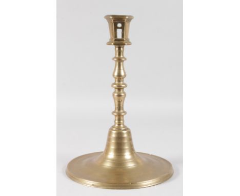 A LARGE CIRCULAR BASED BRASS CANDLESTICK. 13ins high.