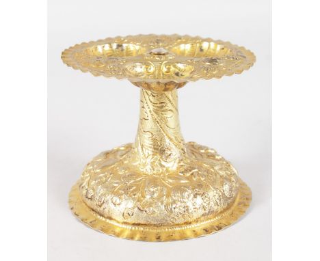 A GERMAN SILVER GILT TRIPLE CIRCULAR PEDESTAL SALT, the top with three shells, and repousse fruit on a circular pedestal base