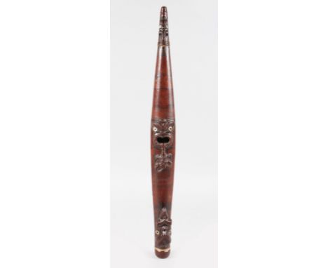 A MAORI CARVED WOOD PIPE, carved with heads, the eyes mother-of-pearl. 19ins long.