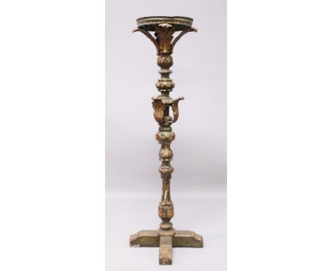 AN EARLY CARVED AND PAINTED PRICKET FLOOR STANDING CANDLESTICK, with circular top, leaf carved decoration on a cross shaped b