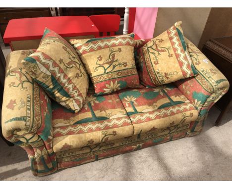 A TWO SEATER SOFA BED WITH COLOURFUL UPHOLSTERED DESIGN 